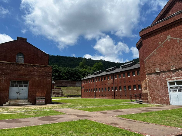 서대문형무소역사관 맑은 날씨 아래 야외 산책로를 따라 배치된 붉은 벽돌조의 감옥 건물들과 주변 산세