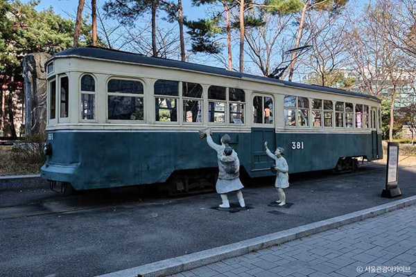 서울역사박물관 박물관 야외에 전시된 옛 전차 381호와 전차를 타려는 모녀 조각상